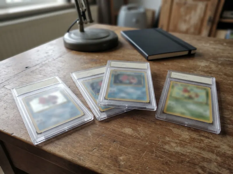 Graded Pokémon kaarten in harde plastic slabs op een bureau